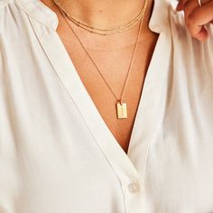 Our best selling tag now holds the name that matters most! This classic piece is beautiful on its own, but also pairs perfectly with our birthstone charms, and circle and heart tags. vermeil is a sterling silver base with 100+ mls of 24k gold mini dog tag is 5/8″ L x 1/3″ W "mama" engraved on front, no back engraving, ready to ship within 24 hours hangs on 18"chain *model is wearing the mama dog tag on a 24" chain layered with our 30" satellite chain Classic Gold Charm Necklace With Square Pendant, Everyday Hypoallergenic Yellow Gold Charm Necklaces, Gold Hypoallergenic Charm Necklaces For Everyday, Everyday Gold Hypoallergenic Charm Necklaces, Personalized Gold Dog Tag Charm Necklace, Everyday Gold Nameplate Charm Necklaces, Gold Sterling Silver Charm Necklace With Rectangular Pendant, Everyday Gold Nameplate Charm Necklace, Gold Nameplate Charm Necklace With Birthstone