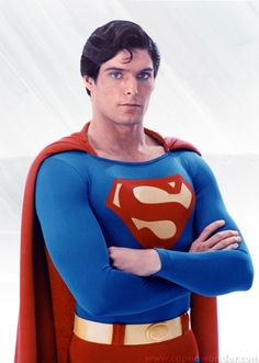 a man in a superman costume standing with his arms crossed