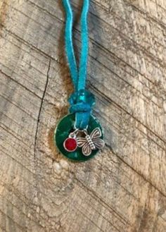 a green necklace with a butterfly on it