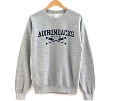 ⚑ Adirondacks New York crewneck sweatshirt ✯ The perfect crewneck sweatshirt for your favorite destination. A great casual pullover crewneck to represent your favorite city or hometown. ✯ Makes a great gift! ⌁ Unisex Size ⌁ Printed on the Gildan 18000 Sweatshirt ⌁ Loose fit ⌁ 50% Cotton; 50% Polyester (fibre content may vary for different colors) ⌁ Medium fabric (8.0 oz/yd² (271.25 g/m ⌁ Sewn in label ⌁ Runs true to size 𝑴 𝑬 𝑨 𝑺 𝑼 𝑹 𝑬 𝑴 𝑬 𝑵 𝑻 𝑺 (𝚒𝚗𝚌𝚑𝚎𝚜 𝚆𝚡𝙻) 𝚂 | 𝟸𝟶𝚡𝟸𝟽 ? New York Crewneck, South Haven Michigan, Michigan Sweatshirt, New York Sweatshirt, Traverse City Michigan, Jersey Sweatshirt, Lake Placid, Traverse City, Favorite City