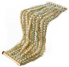 the beaded necklace is gold and white with blue beads on each strand, along with a golden bar