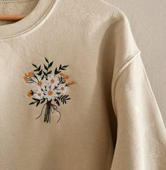 a sweater with flowers embroidered on it