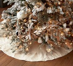 a white christmas tree with gold and silver ornaments