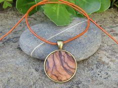 "Lovely bronze pendant medallion with a handmade cabochon Ø 25 mm - 0.98 inches in fine olive wood with a 75 cm - 29.5 inches long bronze plated chain or an adjustable leather cord 1 meter ( 39.37 \" ) naturally the grain of the olive wood can vary from item to item , but in any case you will get a pendant with an olive wood cabochon with beautiful grain handcrafted by us in Portugal the olive wood is finely sanded and oiled with olive oil" Brown Medallion Amulet Necklace, Brown Amulet Style Round Pendant Necklace, Brown Amulet Style Necklace With Round Pendant, Brown Amulet Necklace With Round Pendant, Bohemian Natural Wood Necklaces As Gift, Bohemian Natural Wood Necklace As Gift, Brown Necklace With Large Round Pendant, Handmade Natural Wood Pendant Jewelry, Bohemian Handmade Circle Necklace