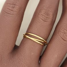 This interlocking ring features a versatile and stylish design, making it perfect for stacking or wearing on its own. Made from high-quality gold, this ring is a timeless accent piece that adds a touch of elegance to any outfit. A must-have for any jewelry collection. 14k gold filled interlocking fidget ring with 3 bands Modern Adjustable Hypoallergenic Stackable Rings, Adjustable 14k Gold Minimalist Bypass Ring, Modern Adjustable Stackable Rings For Anniversary, Adjustable Modern Stackable Toe Rings, Modern Adjustable Stackable Toe Rings, Modern Stackable Toe Rings For Promise, Adjustable Bypass Ring With Modern Twist, Adjustable Yellow Gold Rings For Everyday Use, Minimalist Adjustable 14k Gold Bypass Ring