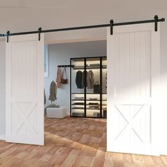 an open closet with sliding doors and clothes on hangers