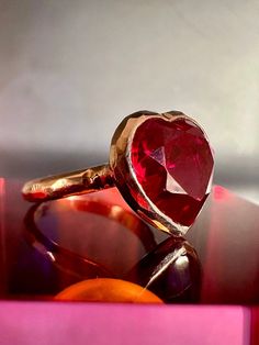 With its playful, symbolic vibe and juicy red color, this striking ring from our Simplicity Collection is a perfect addition to any modern collection. Large red heart shaped ruby is encased in meticulously hand finished band. This stunning ring will make a fun alternative to a traditional cocktail ring. Available for immediate shipping: Ruby 11mm x 12mm Set in 9K rose gold Size: 17.5 Please contact us for sizing options Ruby Heart Ring, Heart Shape Ring, Rose Gold Band Ring, White Diamond Earrings, Ruby Heart, Cognac Diamonds, Rose Gold Beads, Handmade Fine Jewelry, Solid Gold Chains