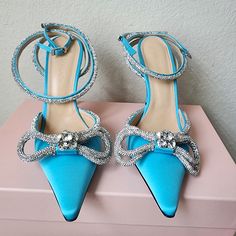 Brand New, Never Been Worn. Double Bow Embellished Sandals Made In Italy Color/Material: Ocean Blue Satin Design Details: Silver-Tone Hardware, Crystal Embellishments And Double Bow Adjustable Ankle Strap With Buckle Closure Lightly Padded Leather Insole Smooth Leather Sole 4.5in Heel Summer Embellished Blue Heels, Luxury Blue Heels With Rhinestones, Luxury Embellished Blue Heels, Blue Embellished Heels With Pointed Toe, Blue Embellished Heels For Special Events, Blue Pointed Toe Heels With Rhinestones, Blue Rhinestone Pointed Toe Heels, Embellished Blue Heels For Gala, Blue Embellished Heels For Gala