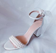 Introducing our exquisite and comfortable wedding sandals, meticulously crafted with the elegant bride in mind. Handmade with utmost care and attention to detail, these wedding pearl heels are the epitome of grace and sophistication. Our Wedding Shoes are designed to capture the essence of romance and enchantment. The delicate organza bow, adds a touch of ethereal charm to these ivory pearl block heels. These comfort shoes are specifically created to ensure that you can dance the night away with ease and grace on your special day. The block heel provides stability and support, allowing you to confidently navigate any terrain. The soft leather lining adds a luxurious feel, pampering your feet with each step you take. Key Features: *Made to order *Elegant and timeless design *Handcrafted wit Feminine Block Heel Wedding Sandals, Feminine Block Heel Sandals For Wedding, White Pearl Embellished Wedding Shoes For Bridesmaids, Wedding Sandals With 4-inch Heel And Round Toe, Elegant Summer Wedding Shoes With Round Toe, Elegant Summer Wedding Guest Shoes, Summer Wedding Shoes With 4-inch Heel, Closed Toe Wedding Shoes For Summer Guests, Open Heel Wedding Shoes With 4-inch Heel For Guests