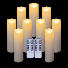 six white candles with remote controls in front of them