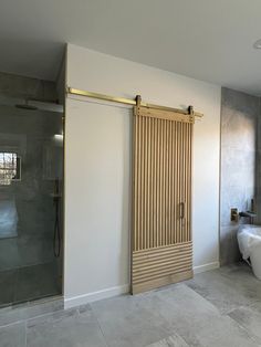 a bathroom with a tub, shower and sliding glass door