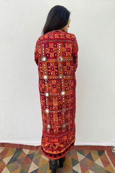 Long Boho Patchwork Quilted Festival Coat from AlMiro The most rarest piece of our collection! Stunning up-cycled coat dyed in red orange shade, handmade from authentic tribal Indian Banjara vintage fabric. This fabric was created by the ancient nomadic tribes of north India. The Banjara people are believed to have descended from European gypsies thousands of years ago, which would explain its cool boho look. With a hand embroidered design, two side pockets and side slits, this one of a kind jac Long Patchwork Kimono For Festivals, Long Patchwork Festival Kimono, Navratri Long Sleeve Kurta With Geometric Embroidery, Long Patchwork Kaftan, Bohemian Kaftan With Dupatta For Festivals, Long Kaftan With Dupatta For Festivals, Navratri Festival Kaftan With Mirror Work, Festival Kaftan With Mirror Work, Bohemian Mirror Work Kaftan For Festivals