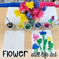 flowers sit in vases on top of paper and paint