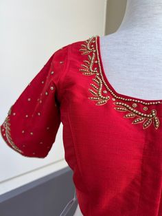 Bright Red Color Raw Silk Readymade Blouse with beautiful Handwork Work in beads and Zircon. Item : Readymade BlouseReady-to-Wear : YesSize : 36 (Can be opened to Size 40)Color : Bright Red Blouse Fabric : Soft Silk Lining : Yes, it is fully lined Padded or Non-Padded : PaddedClosure: Front Closure with hooks.Disclaimer - : -This is a Standard Size blouse. We do not guarantee perfect fit as every body and shape is different. Little or no alteration would be required to get the perfect fit. - Col Festive Red Top For Wedding, Elegant Party Blouse With Motifs, Elegant Festive Tops With Dori Work, Elegant Tops With Dori Work For Festive Season, Red Wedding Sets With Padded Blouse, Red Wedding Set With Padded Blouse, Red Embroidered Tops For Wedding, Traditional Embellished Tops For Formal Occasions, Formal Embroidered Tops For Festivals