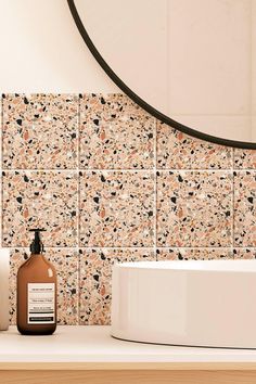 a bathroom with a sink, mirror and soap dispenser on the counter