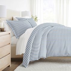 a bed with blue and white striped sheets