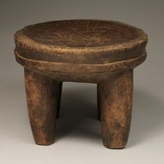 an old wooden stool sitting on top of a table