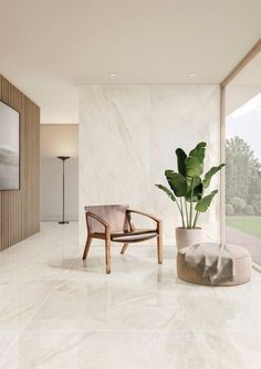 a living room with white marble walls and flooring, a plant in the corner