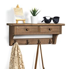 a coat rack with two drawers and sunglasses on it