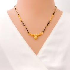 This 22k gold mangal sutra, weighing 9.6 grams, features a beautifully textured design that enhances its radiant yellow gold finish. The black bead detailing adds a traditional touch, while the 16-inch necklace length provides a comfortable and elegant fit. The 0.25-inch drop length creates a subtle yet refined accent, and the hook lock ensures security and ease of wear. Combining cultural heritage with a modern aesthetic, this piece is ideal for those seeking a timeless yet stylish symbol of marital unity. PRODUCT DETAILS Gold Purity(karat): 22k Item Weight(grams): 9.6 Item Finish: Yellow Gold Stone: Black Bead Necklace Length: 16" Drop Length: 0.25" Lock Style: Hook Lock Elegant Yellow Necklace For Puja, Black Round Beads Necklace For Diwali, Festive Black Necklace With Gold Beads, Black 22k Gold Jewelry With Round Beads, 22k Dual-tone Yellow Gold Necklaces, Dual-tone 22k Yellow Gold Necklaces, Elegant Black Temple Necklace As Gift, Elegant Black Beaded Jewelry For Puja, Elegant Black Temple Necklace Gift