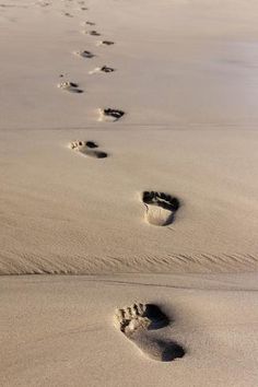 two footprints are seen in the sand at the beach