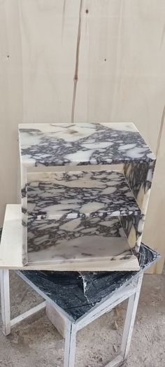 two pieces of marble sitting on top of each other in a room next to a wall