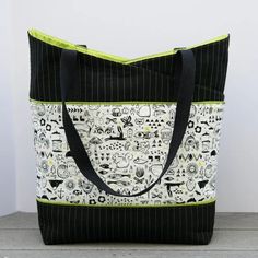 a black and white tote bag sitting on top of a wooden table