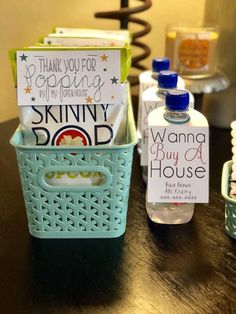 a bottle of water sitting on top of a table next to a basket with cards in it