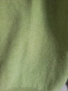 the back of a green sweater with buttons on it's chest and bottom half