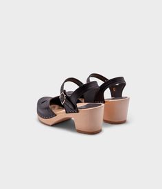 Experience the perfect balance of vintage and modern with our Copenhagen clog sandals. Crafted from natural materials, these stylish sandals embody everything we cherish about fashion from bygone eras while embracing the contemporary spirit of today. Clog measurements:Heel height: 2 5/8” (6.5 cm)Toe height: 1 1/2” (3.8 cm) Fit:NarrowLeather:Vegetable tanned leatherClogs consist of:Base: European lime wood Sole: Rubber sole Fastening: StaplesOther: Metallic Buckle High Heel Clogs, Cork Sandals, Wooden Clogs, Clog Sandals, Stylish Sandals, Toe Designs, Favorite Dress, Boot Shop, Black Sandals