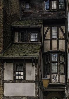 an old building with a clock on the side of it's face and windows