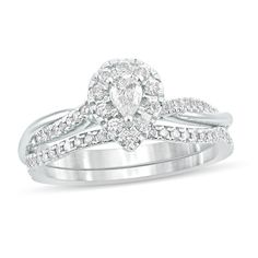 a wedding ring set with a pear shaped diamond in the center and side stones on each band