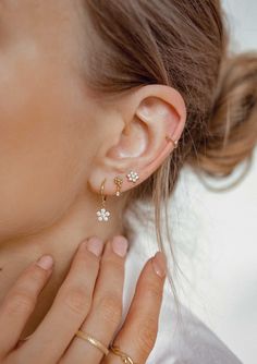 Made from solid 925 sterling silver, these are small stud earrings that have a delicate metallic flower with six 'petals' that sits on the ear lobe, a tiny square zirconia hanging underneath and silver butterfly clasps. Compact, with a timeless design, these studs will pair well with other delicate hoops or studs. 🎁 Packaging: Beautifully packed in a box, ready for gifting. 🏷️ This product is made of sterling silver -- easily recognizable by its '925' stamp of authenticity. It is also hypoallergenic, making it suitable for people with sensitive or irritable skin. We recommend avoiding perfume, deodorant or other chemicals. Details: ✅ Material: 925 sterling silver with 18k gold plated, cubic zirconia ✅ Available in gold and silver ➕ Purchase extra earring backs to make sure your favorite Dainty Flower Earrings With Cubic Zirconia, Dainty Flower Earrings In Cubic Zirconia, Delicate Tiny Sterling Silver Flower Earrings, Dainty Sterling Silver Single Flower Earring, Dainty Single Flower Shaped Earring, Tiny Minimalist Flower Earrings, Minimalist Jewelry With Matching Flower-shaped Earrings, Tiny Sterling Silver Flower Earrings, Dainty Flower-shaped Cubic Zirconia Earrings