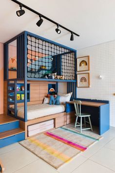 a child's bedroom with bunk beds, desk and stairs