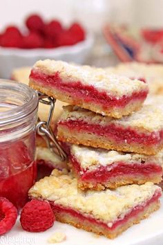 raspberry shortbreads stacked on top of each other next to a jar of jam