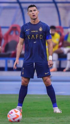 a man standing on top of a field next to a soccer ball in front of him