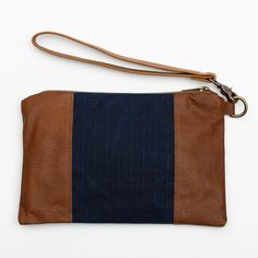 Stylish and durable, this Eastport Clutch is made to accompany you on all of your travels. Perfect for those on the go! Attach the Eastport Clutch to the inside of the Saco River tote Bag or the Fore Street Tote Bag (sold separately) to make a stylish set. Due to the nature of the leather, variations in color may occur. Made in a solar-powered workshop in Maine. Includes detachable leather wrist strap with a bronze lobster clasp built-in leather hand clutch strap zip-top closure Materials waxed Rockport Maine, Hand Clutch, Navy And Brown, Waxed Canvas, Solar Powered, Leather Purse, Zip Top, Wrist Strap, Full Grain Leather