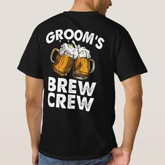 a man wearing a t - shirt that says groom's brew and two mugs of beer