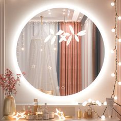 a bathroom vanity with a round mirror and lights on the wall, along with candles