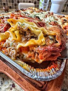 a casserole dish with meat, cheese and sauce on it sitting on a table