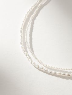 Add some timeless, classic layers to your look with our Layered Pearl Necklace. With one strand of mini pearls and another strand of larger pearls, this layered necklace is all you need. For a full look, pair this double pearl necklace with your other favorite pearl jewelry styles. Classic White Necklace For Layering, Layering Beaded Pearl Necklaces, White Pearl Necklace For Layering, White Pearl Chain Necklace For Layering, Classic Pearl Necklace For Layering, White Pearl Layering Necklaces, Multi-strand Pearl Necklace For Layering, Classic Layering Pearl Necklace, Double Strand Pearl Chain Beaded Necklaces For Layering