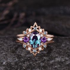 a ring with an amethorate and purple stones in it on top of a rock