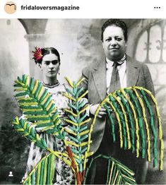 a man and woman standing next to each other in front of a tree with leaves