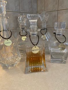 three glass bottles with labels on them sitting on a counter