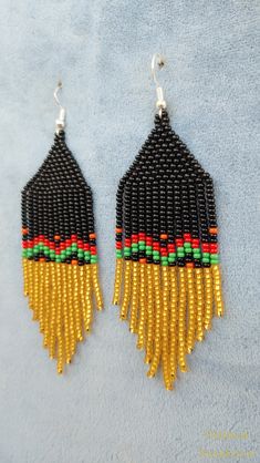 black, yellow and red beaded earrings with fringes on blue fabric background - product images