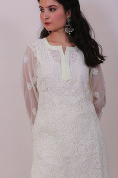 This hand embroidered Leher Georgette Kurti is a beautiful piece to wear at brunch, casual outings and other special occasions.It can be teamed up with hand emboidered chiaknakri pant, sandals and matching earrings to make your getup complete.The color combination with white embroidery is perfect to fit any occasion and comes with matching inner to make you look glamorous. Festive Embroidered Top For Eid, Zari Work Embroidered Top For Eid, Off White Traditional Wear For Spring Wedding, Eid Floral Embroidered Top With Straight Kurta Shape, Festive Embroidered Straight Kurta For Eid, Elegant Embroidered Top For Eid, Spring Resham Embroidered Straight Kurta Top, Spring Resham Embroidered Straight Kurta, Fitted Off White Kurta With Floral Embroidery