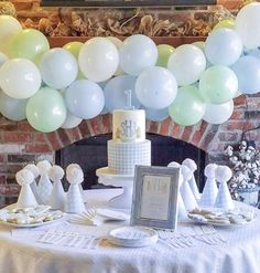 a table with balloons and cake on it in front of a fire place at a wedding