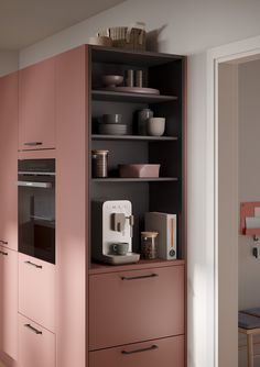 a kitchen with pink cupboards and appliances on the shelves in front of it is an open door