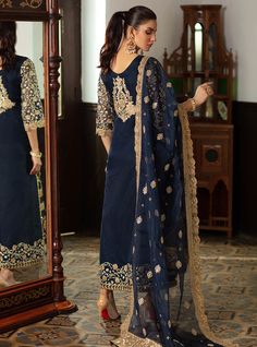 Embroidered Pakistani Suit In Navy Blue Color is a bold ensemble with some magnificent gold embellishments crafted on it giving it a royal yet charming look. This Pakistani Party Dress can be stitched in two styles according to the demand of our lovely customers. Gown: This Embroidered Pakistani Suit comes with a beautiful gown in open style half-cut. The fabric of this gown is organza and is beautifully emblazoned with fine embroidery, tilla, and iridescent sequins. Heavily embellished neckline Unstitched Sets With Gold Embroidery, Elegant Blue Chanderi Churidar, Blue Kurta With Gold Embroidery For Diwali, Elegant Royal Blue Sharara With Traditional Drape, Elegant Blue Sharara For Eid, Diwali Chanderi Sets With Gold Embroidery, Eid Chanderi Sets With Gold Embroidery, Eid Saree Set With Gold Embroidery, Gold Organza Unstitched Suit For Designer Wear