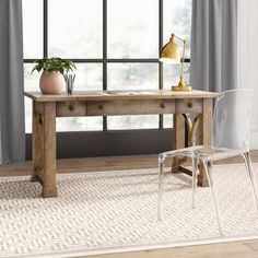 a desk with a chair next to it in front of a window and rug on the floor